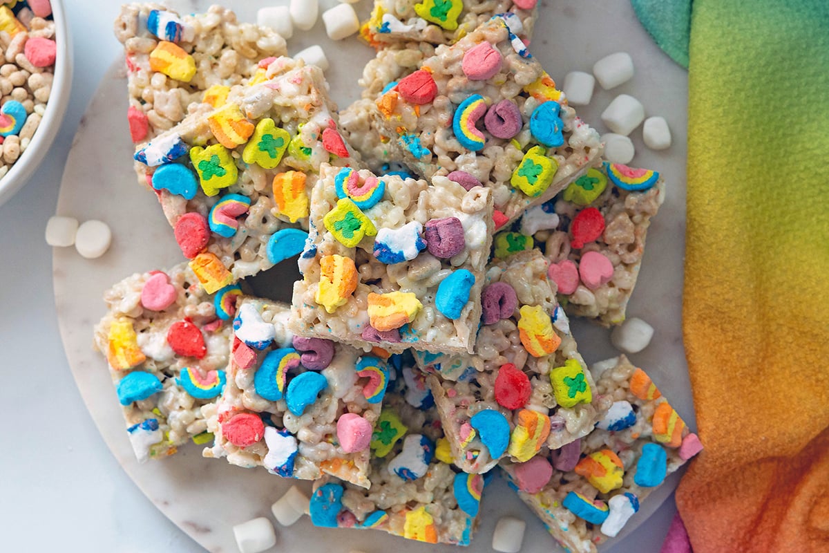 Overhead view of Lucky Charms Rice Krispies treats stacked on a marble platter.