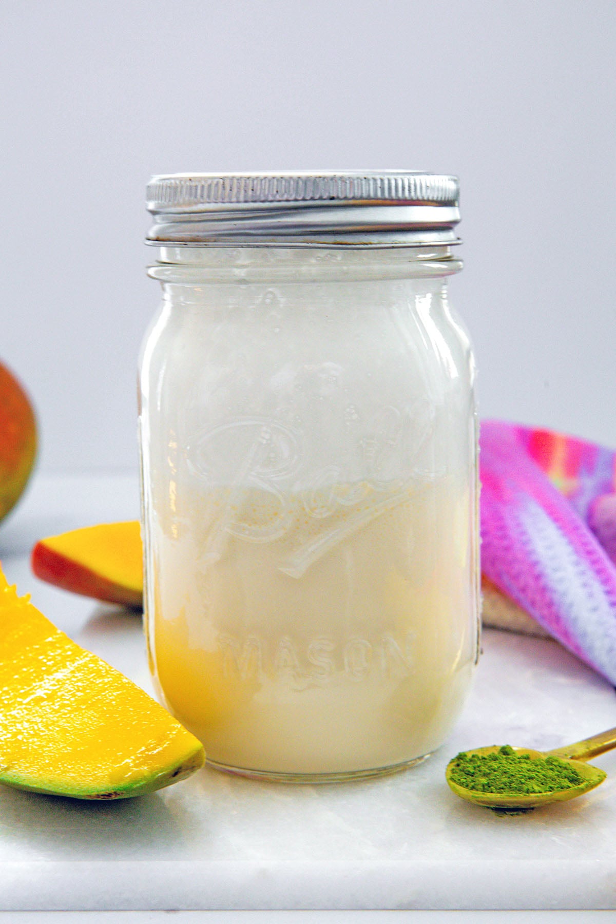 Head-on view of a mason jar filled with mango cold cream.