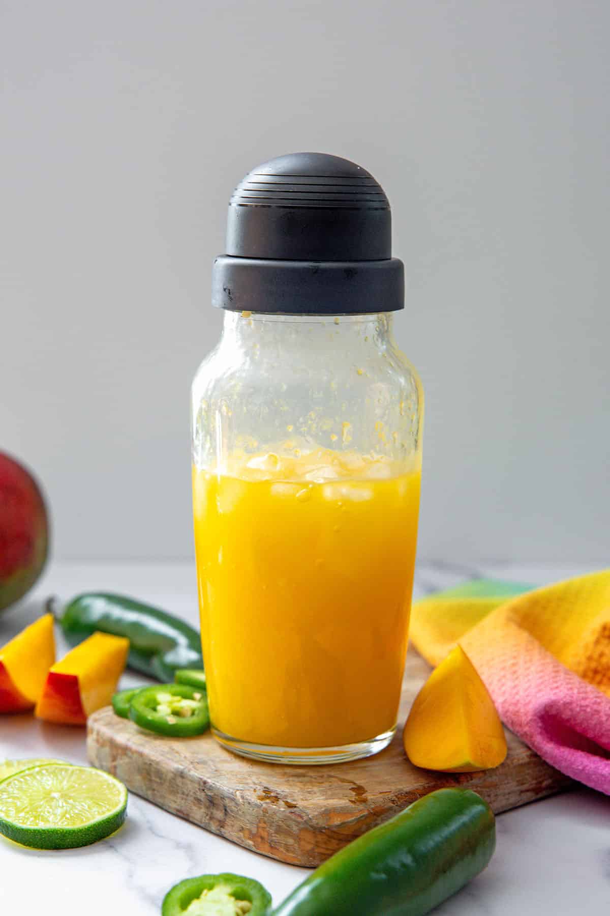 Mango jalapeño margarita in a clear shaker.