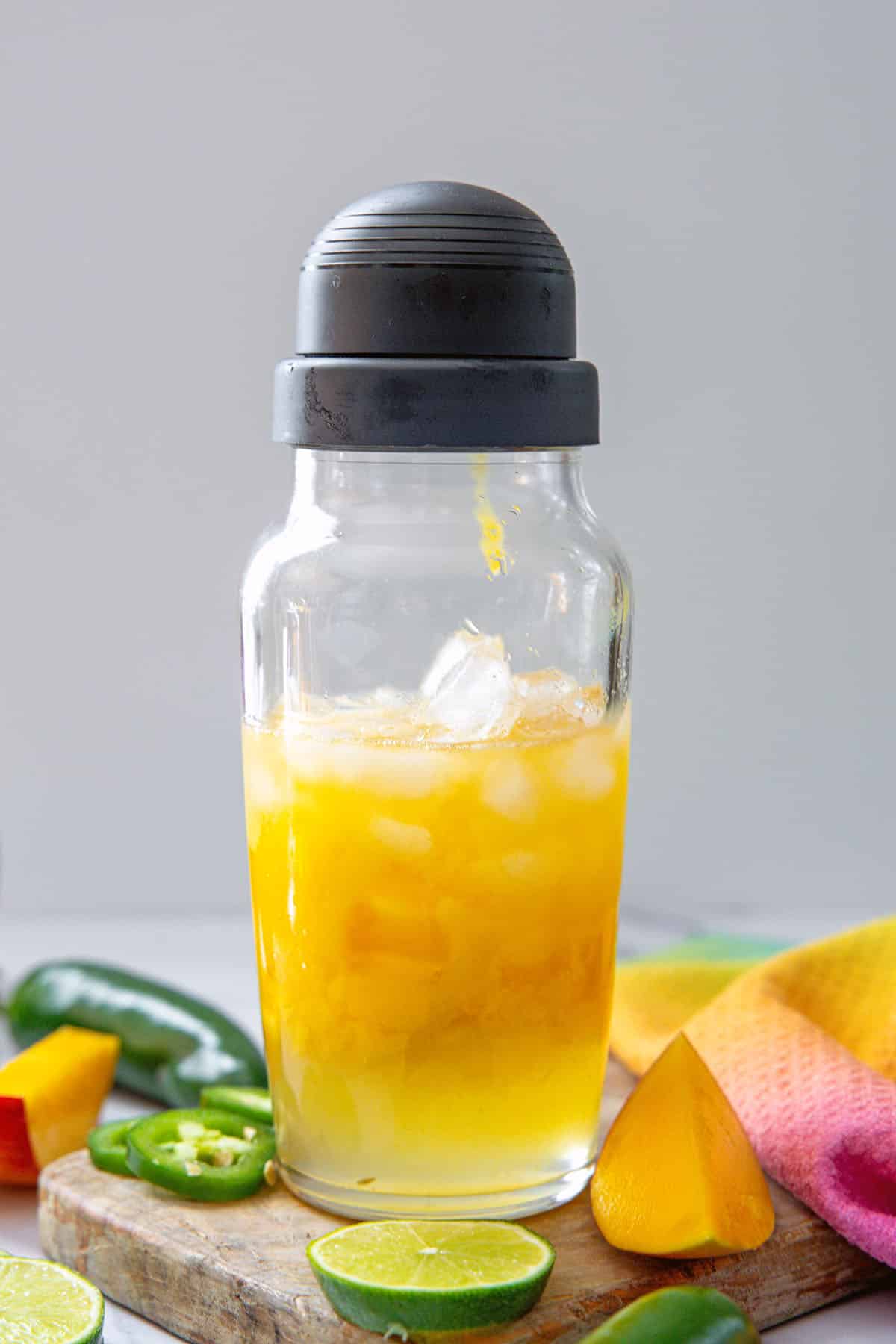 Mango puree, tequila, and orange cointreau in a clear shaker bottle.