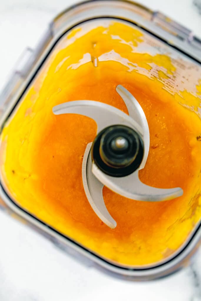 Overhead view of mango popsicle puree in blender