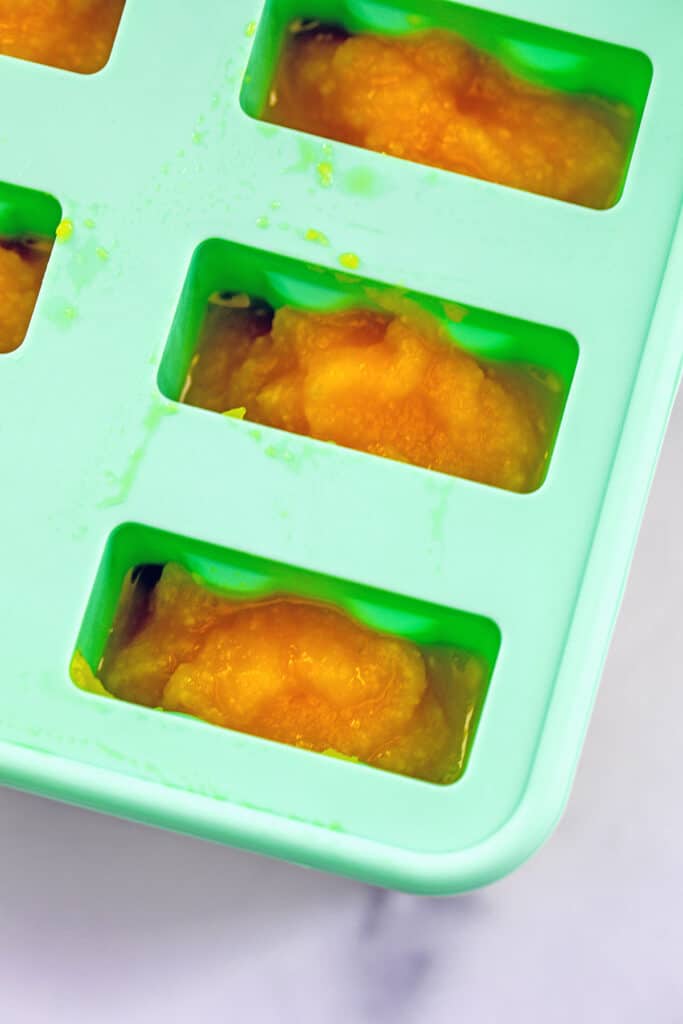 Mango puree in popsicle molds.