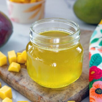 Closeup view of a small jar of mango syrup.