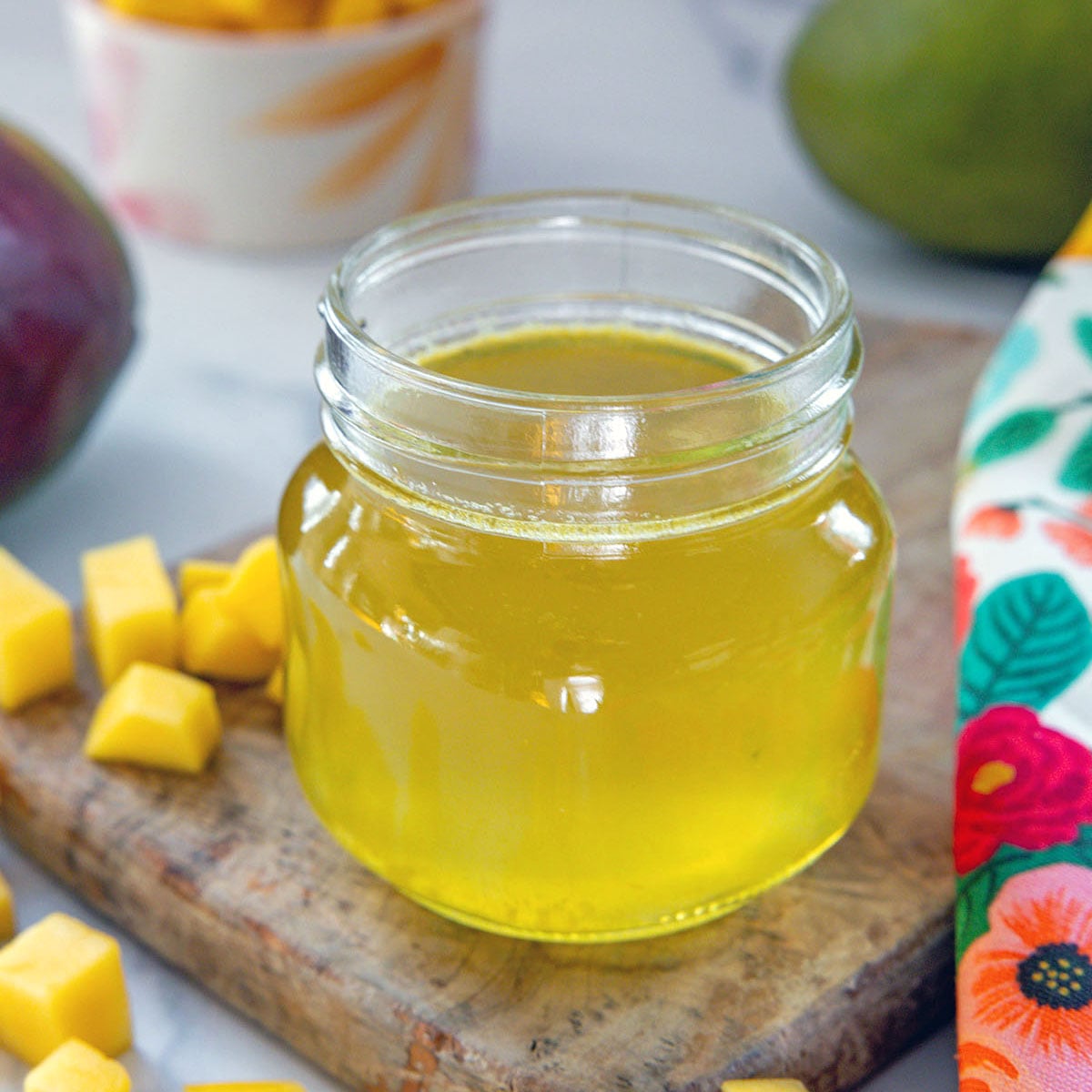 Closeup view of a small jar of mango syrup.