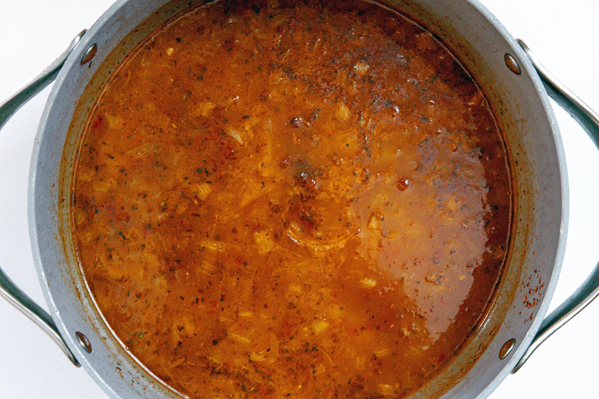Landscape overhead view of soup broth in stockpot.