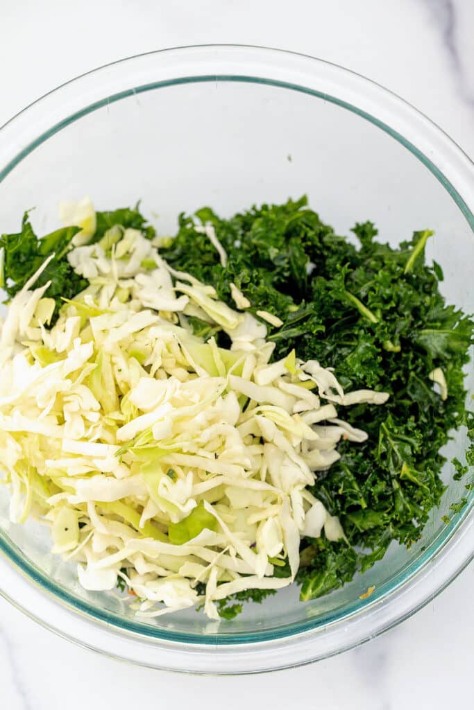 Massaged kale and green cabbage in bowl.
