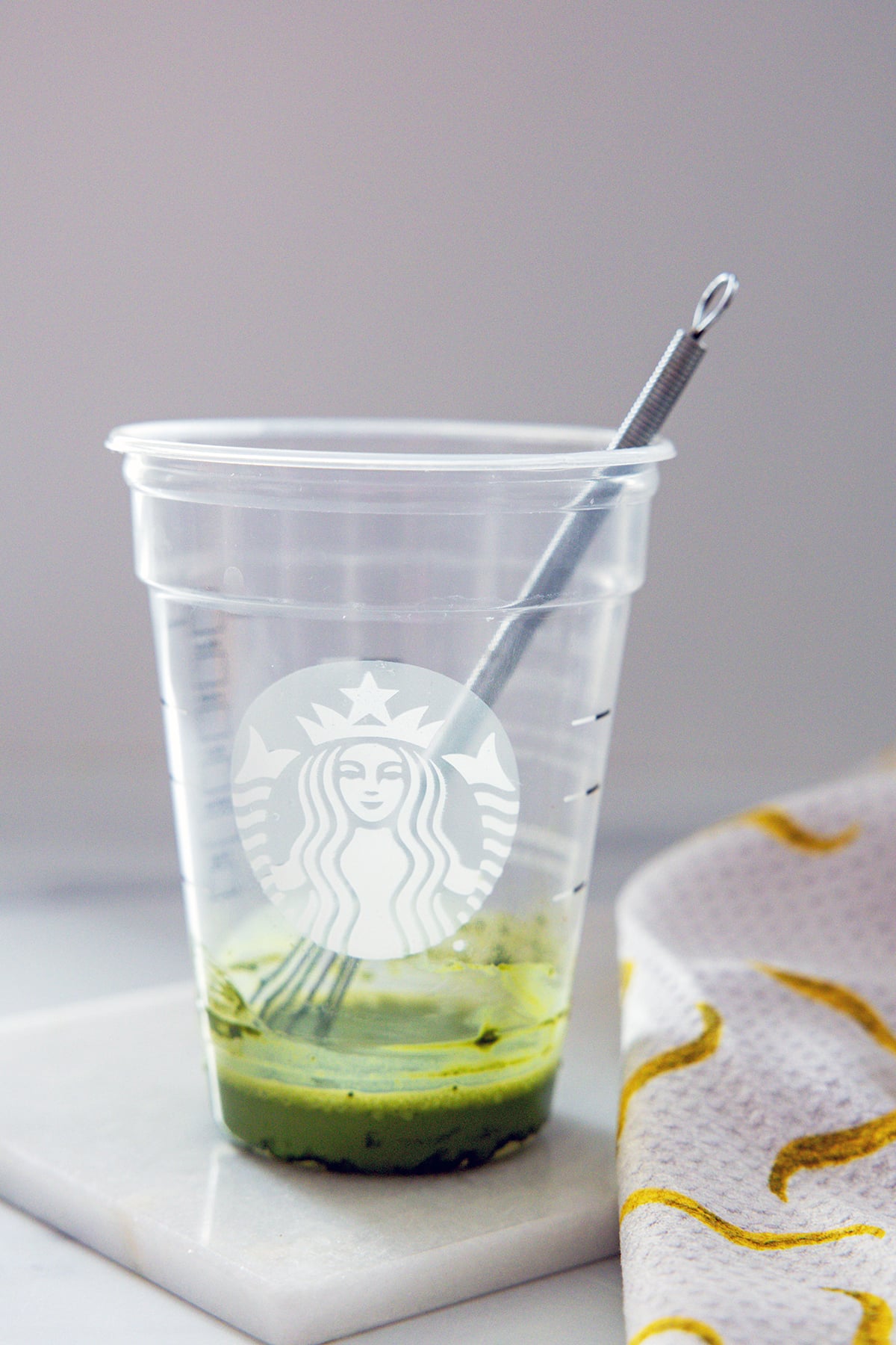 Matcha powder mixed with a little bit of milk in a Starbucks cup.