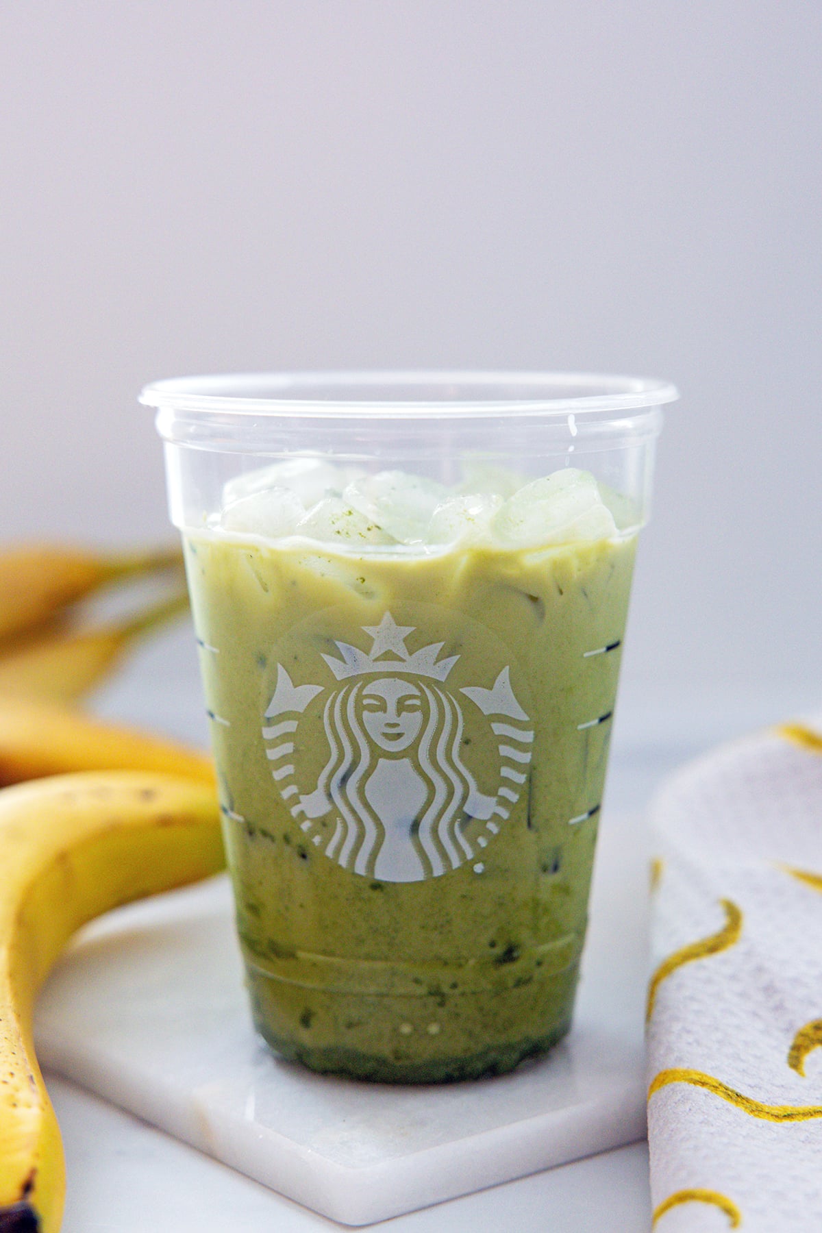 Matcha, milk, and syrup in a Starbucks cup.