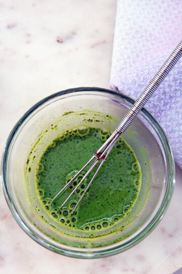 Matcha whisked with milk in a small bowl.