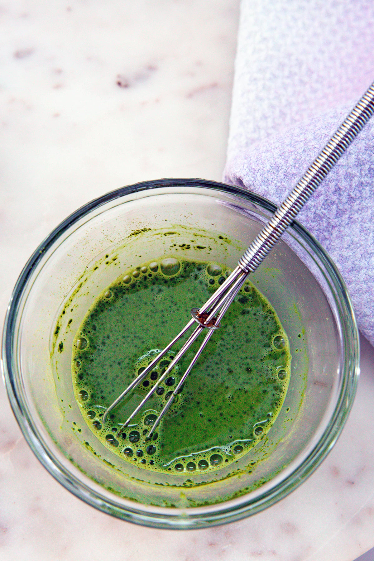 Matcha whisked with milk in a small bowl.