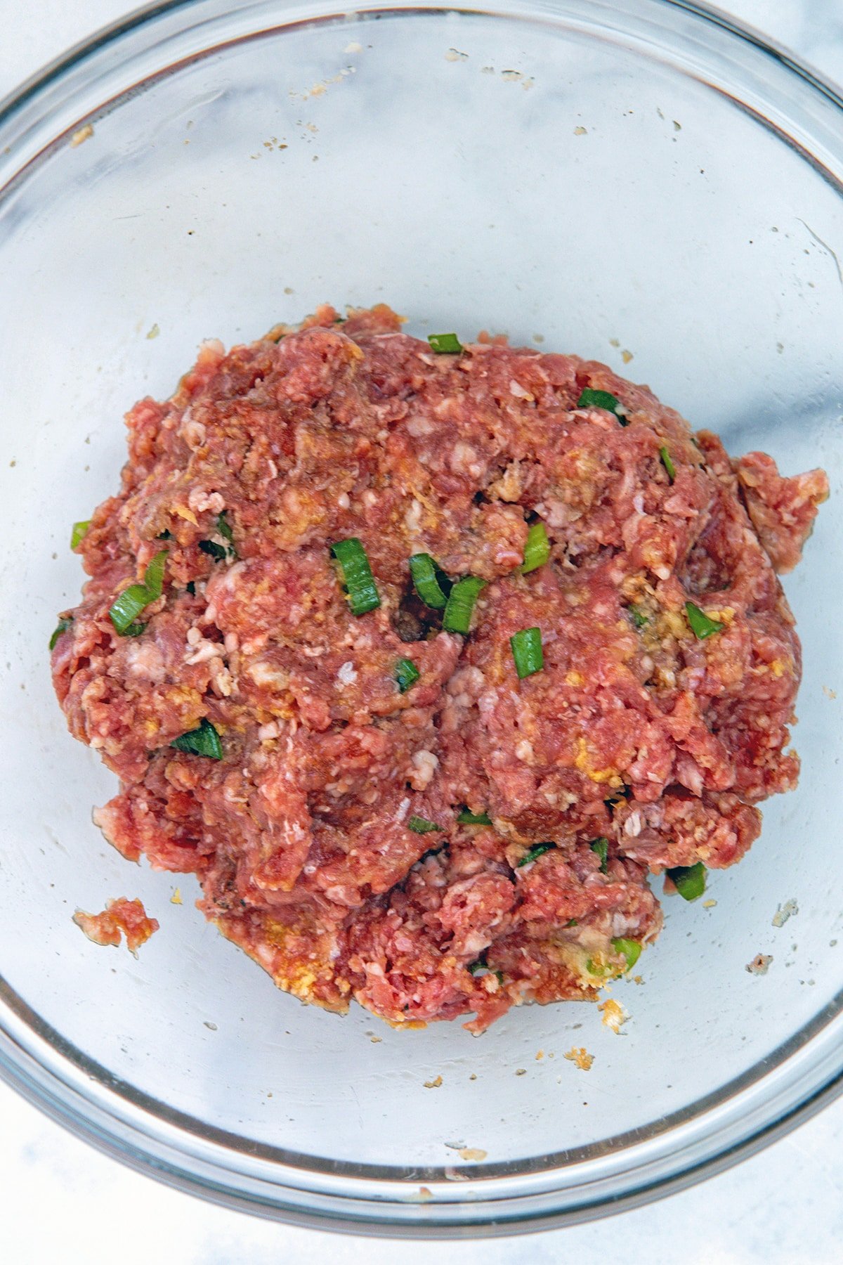 Meatball ingredients all mixed together in bowl.