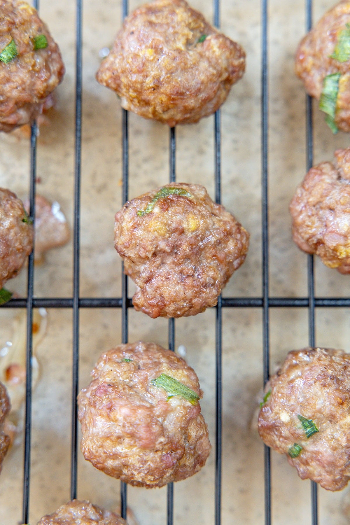Meatballs just out of the oven on baking rack.