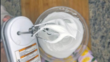 Meringue on hand mixer showing stiff peaks.