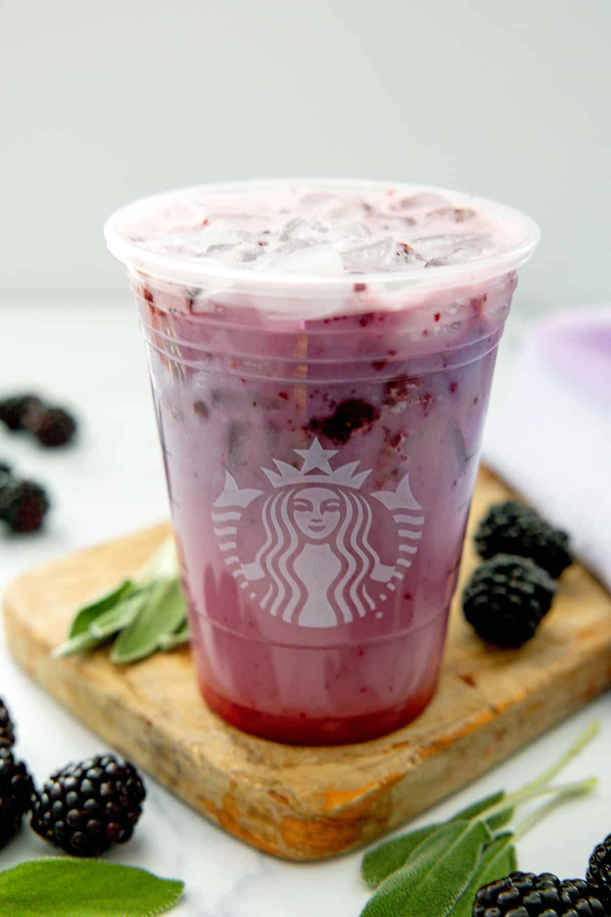 Overhead view of a Midnight Drink with blackberries and sage all around.