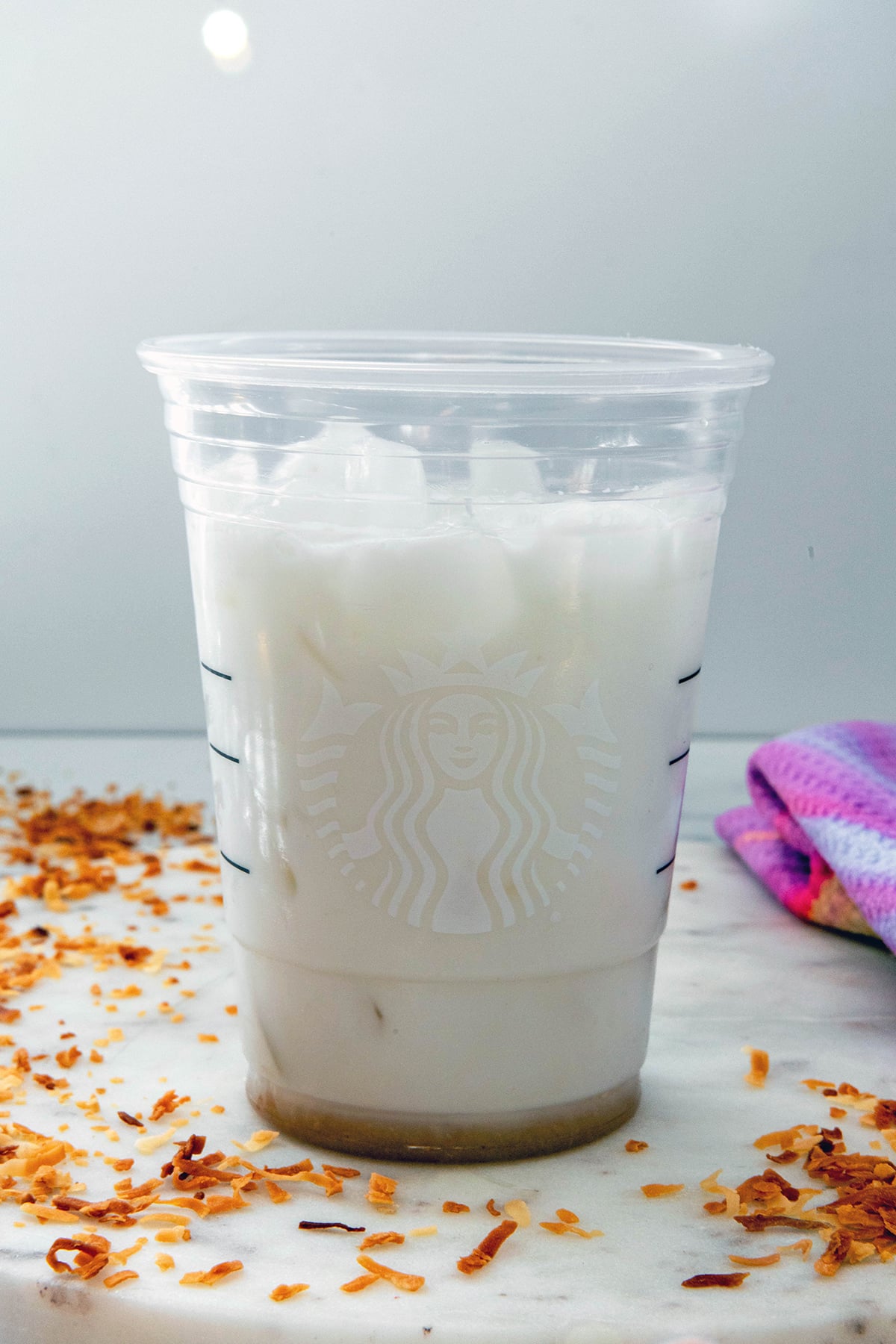 Milk and coconut syrup in a Starbucks cup.