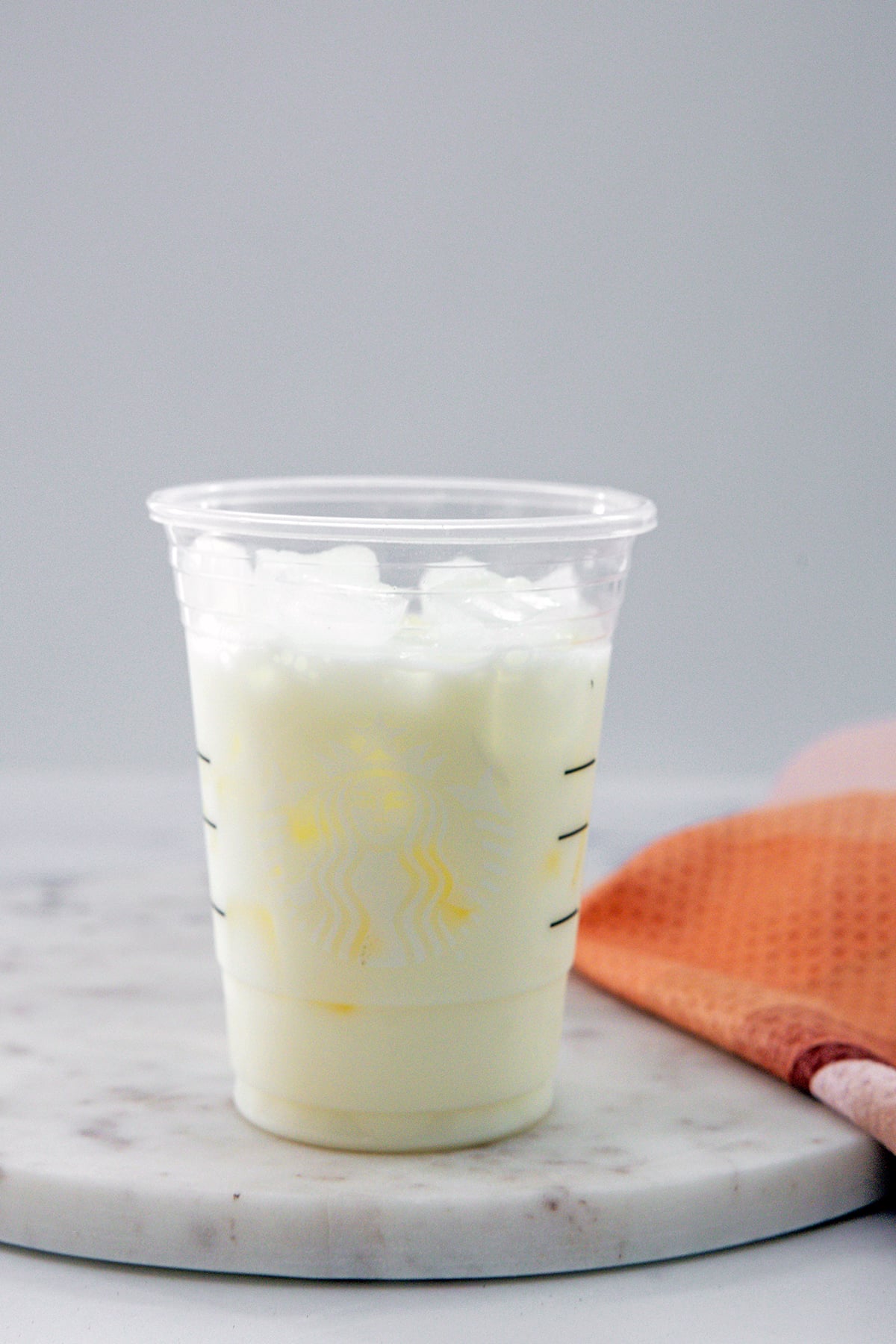 Head-on view of an ice and milk filled Starbucks cup.