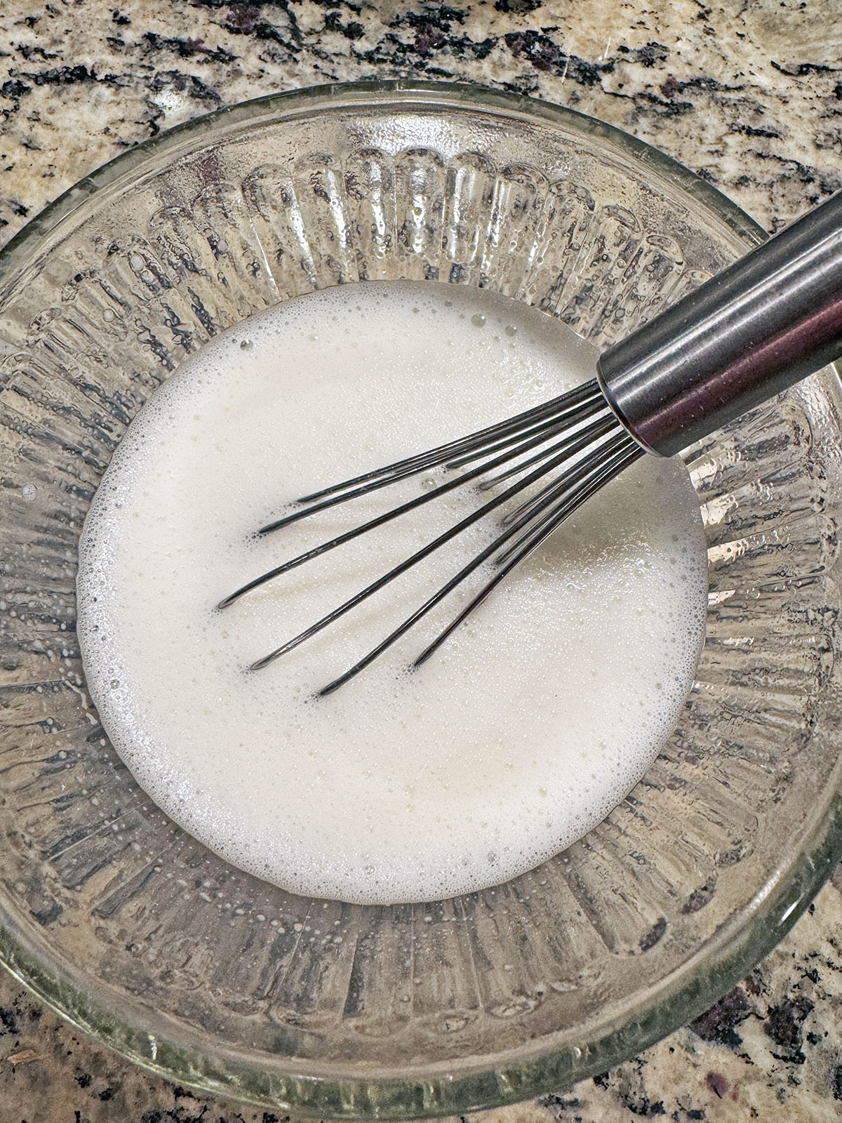 Milk powder and water mixed together in a small bowl.