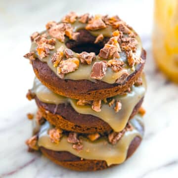 Stack of Milky Way donuts with caramel drizzle and Milky Way candy pieces on top.