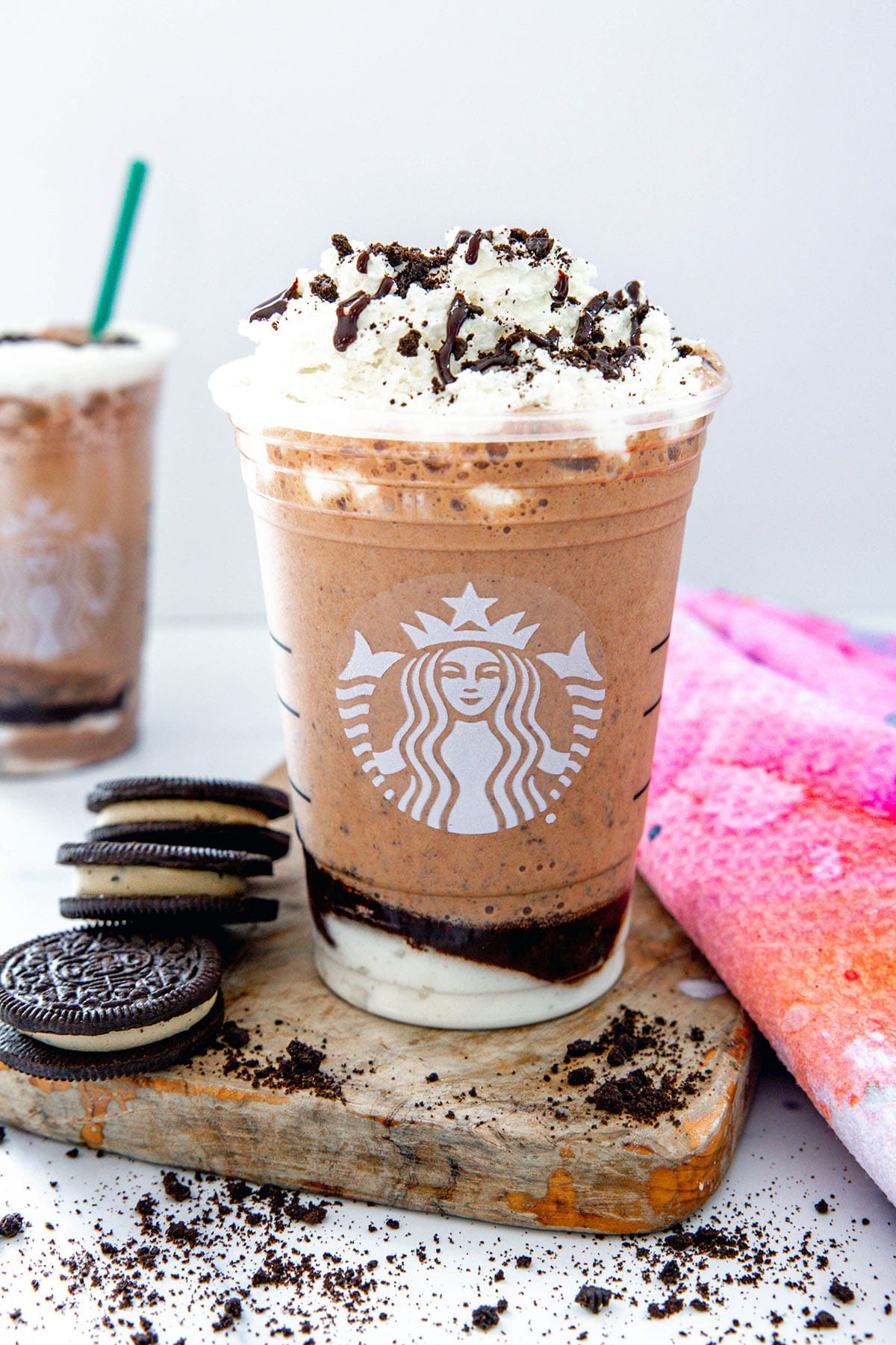 Head-on view of a Mocha Cookie Crumble Frappuccino in a Starbucks cup with Oreo cookies all around.