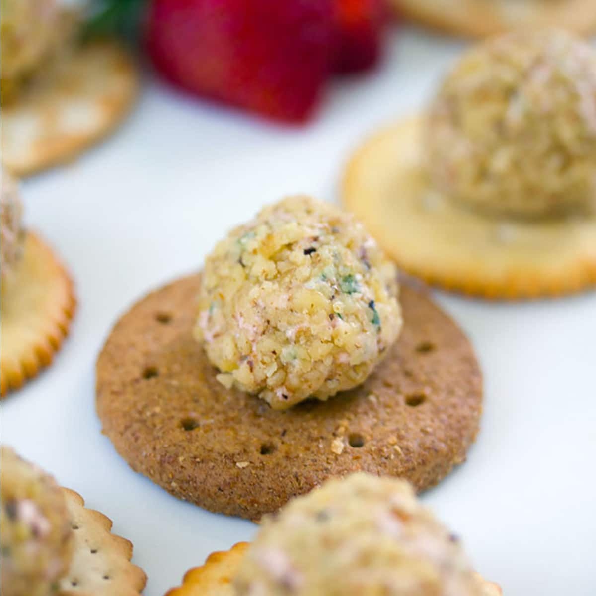 Closeup of a mini cheese ball on a cracker.