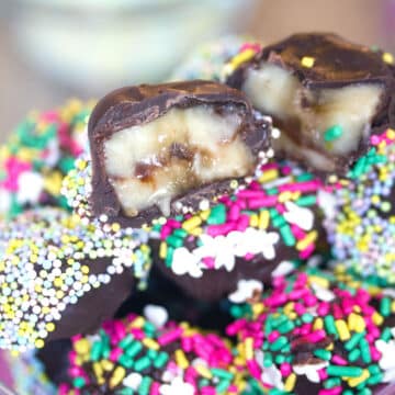 Closeup view of chocolate-covered banana slices with lots of sprinkles.