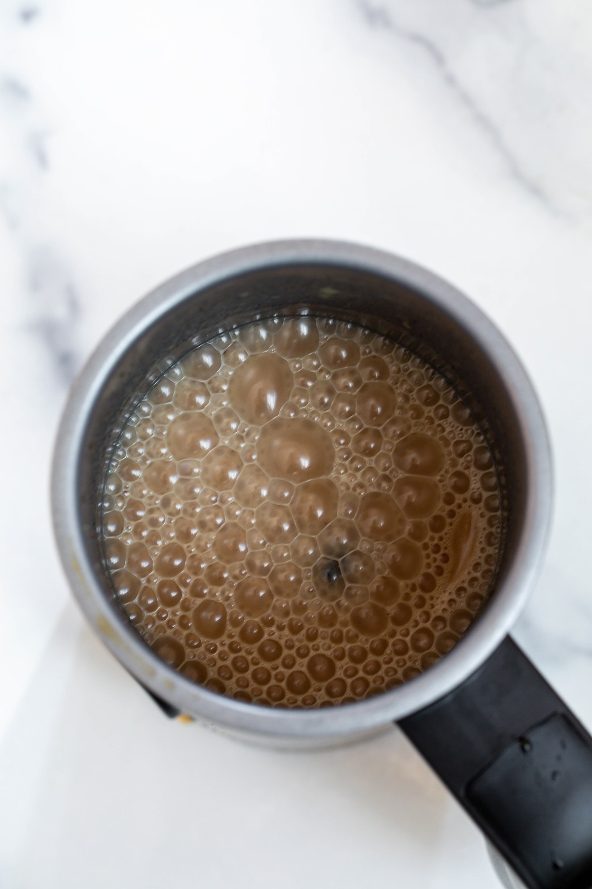 Gingerbread oat milk froth in electric frother.