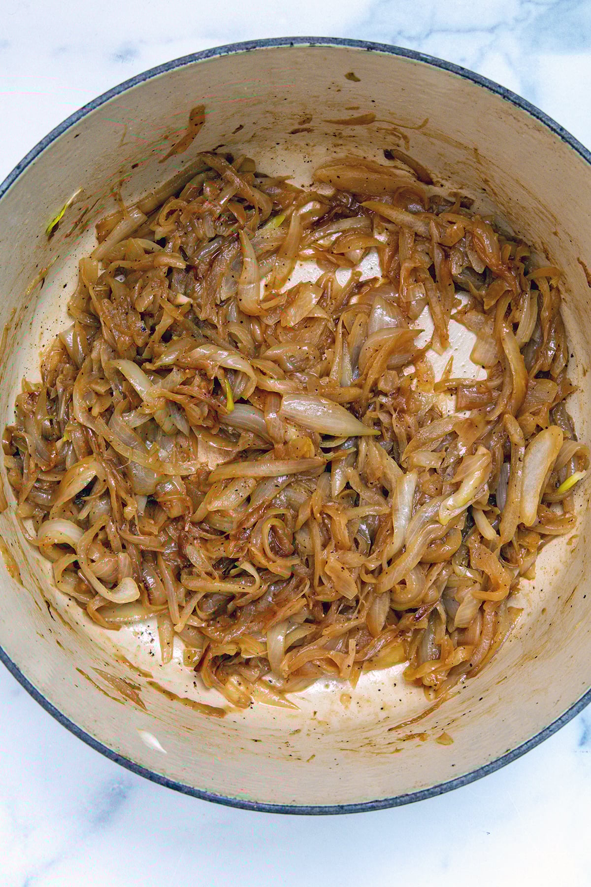 Sliced onions caramelizing in a dutch oven.