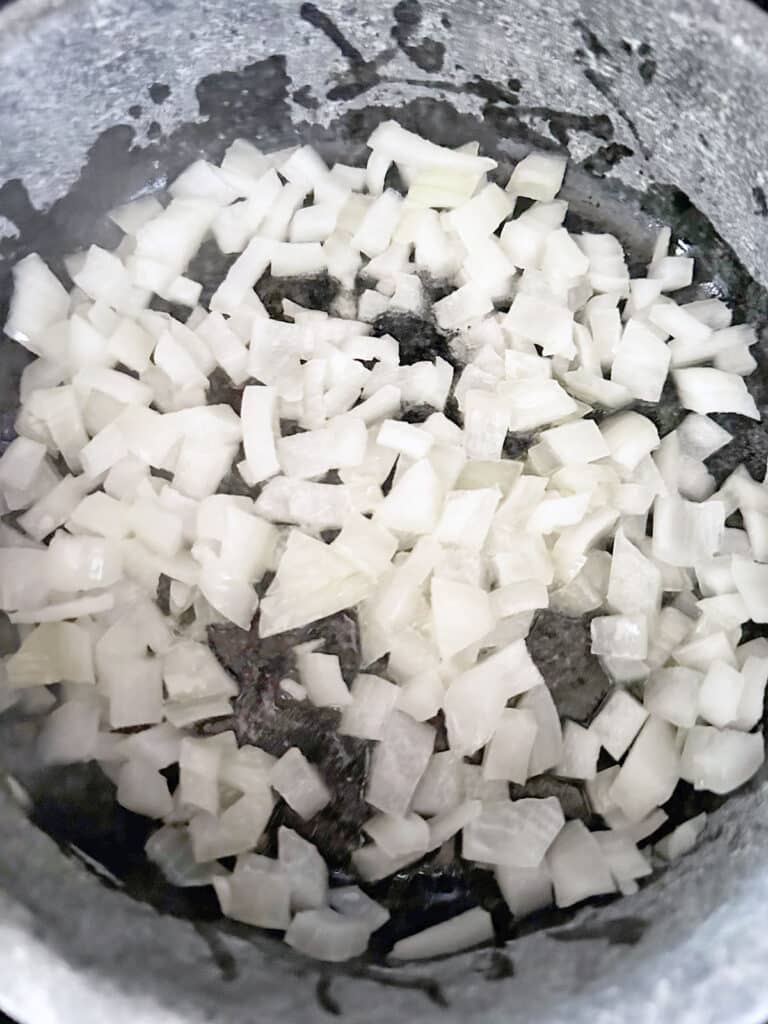 Diced onion in olive oil in a pot.