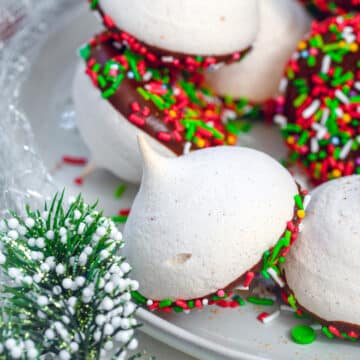 Closeup view of orange gingerbread meringues with chocolate and sprinkles on the bottom.