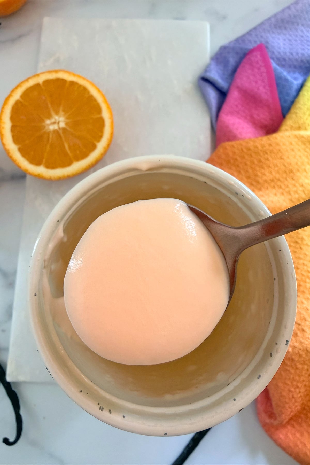 Orange vanilla cold foam on a sppoon.