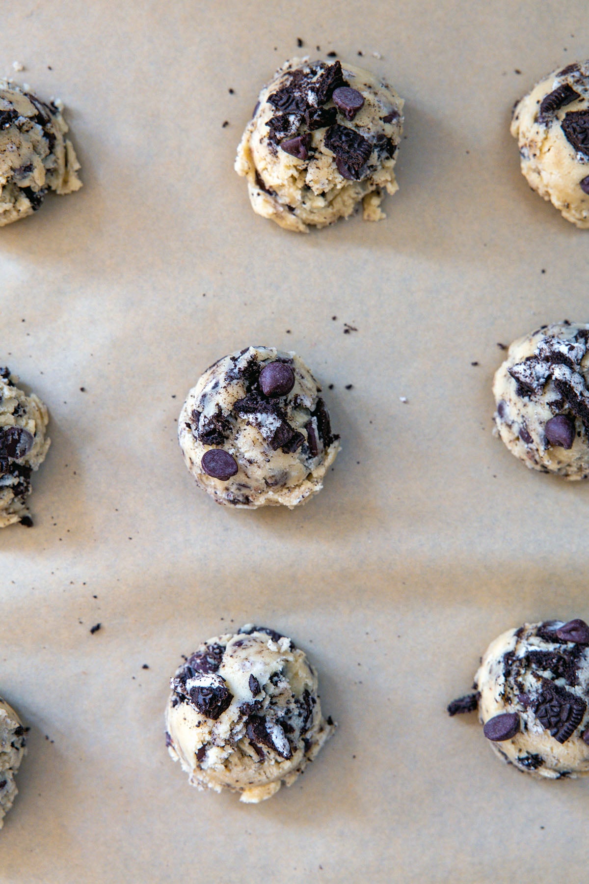 Oreo chocolate chip cookie dough scooped on baking sheet.