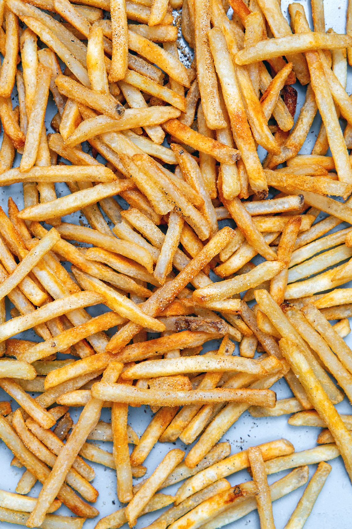 Seasoned french fries backed on baking sheet.