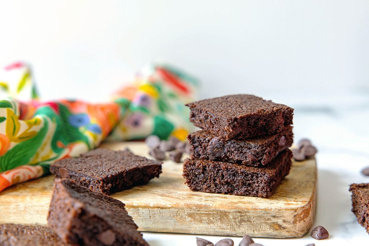 Landscape head-on photo of chocolate brownies on a wooden board.