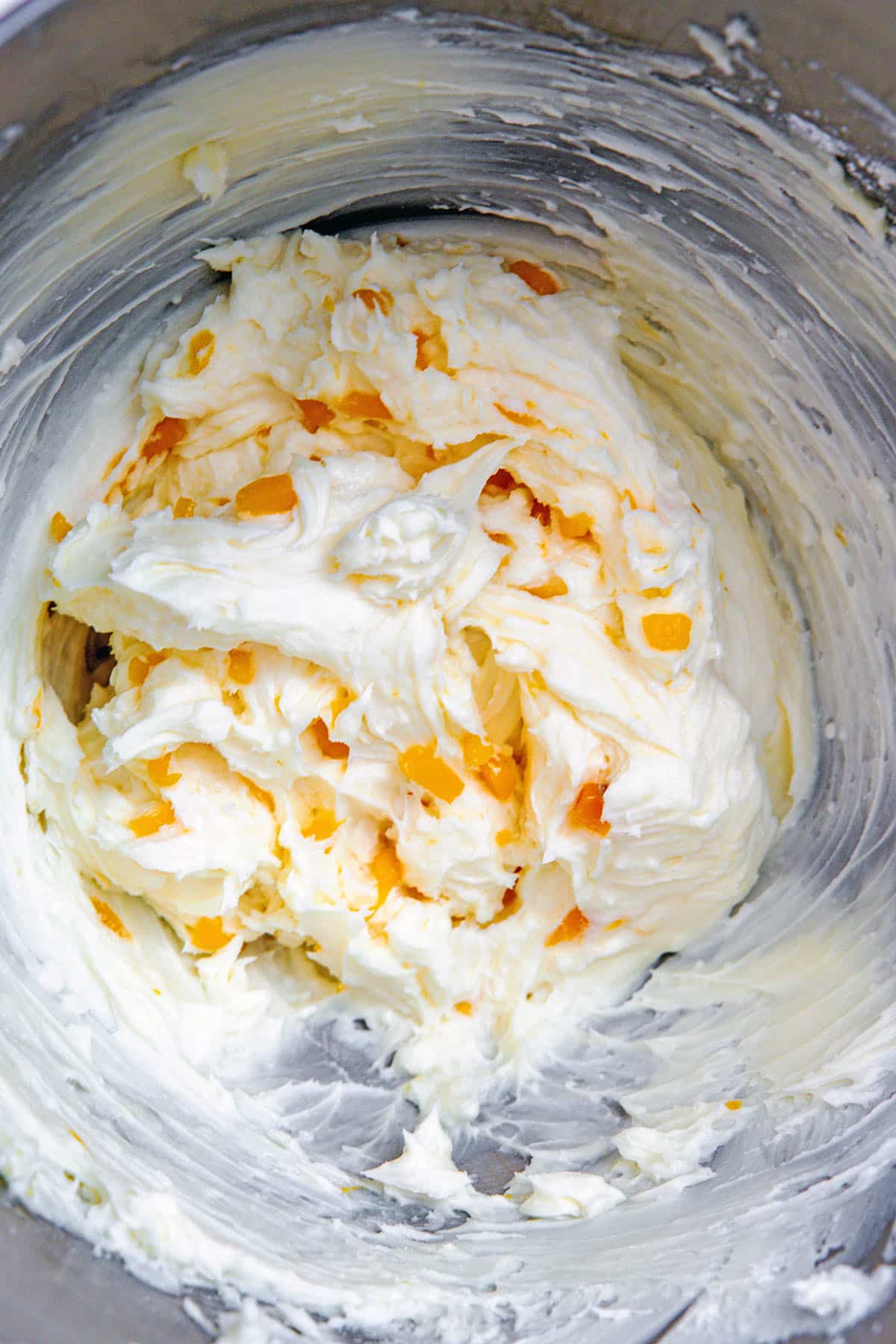 Peach buttercream icing in mixing bowl.