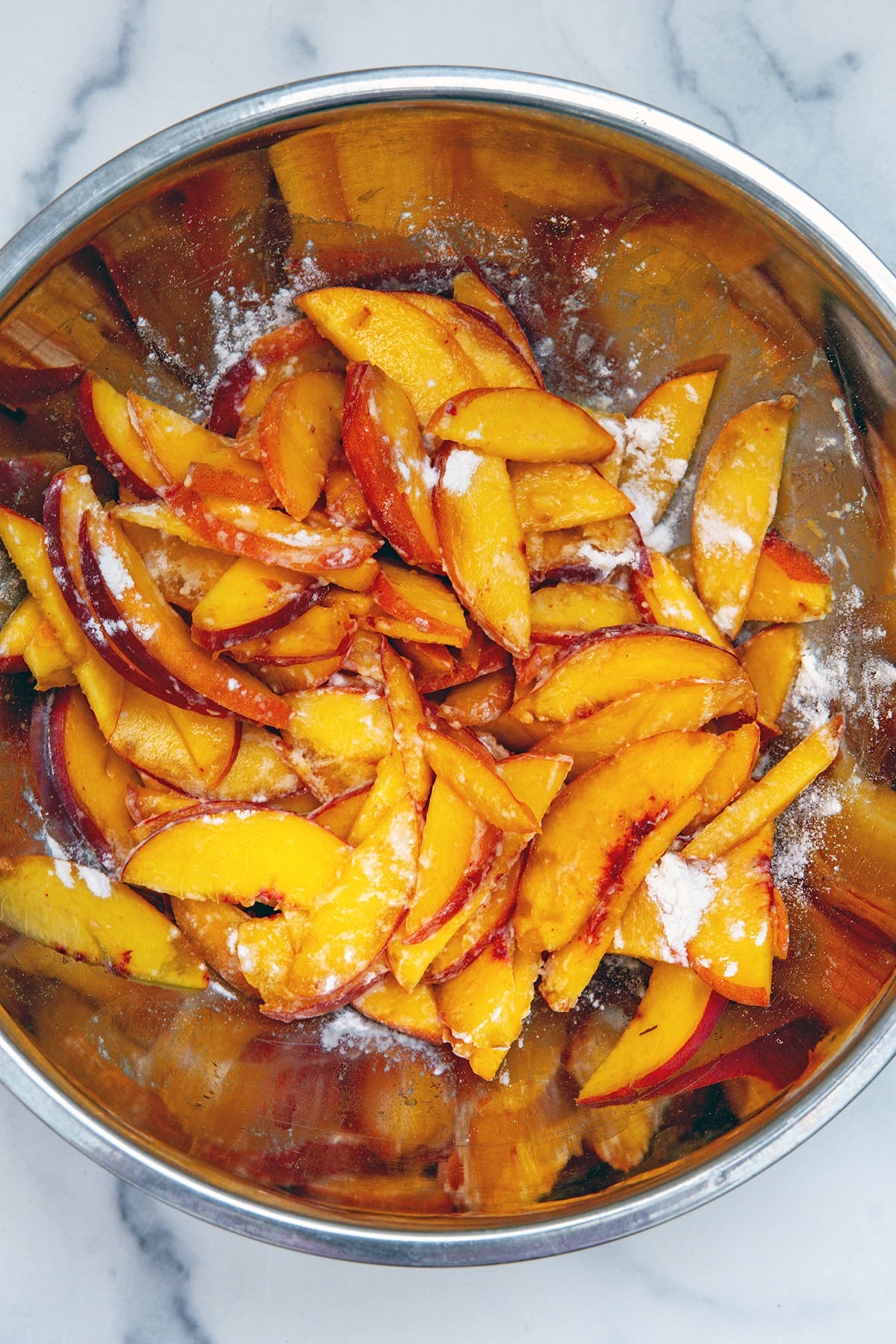 Peach slices in bowl with cornstarch.