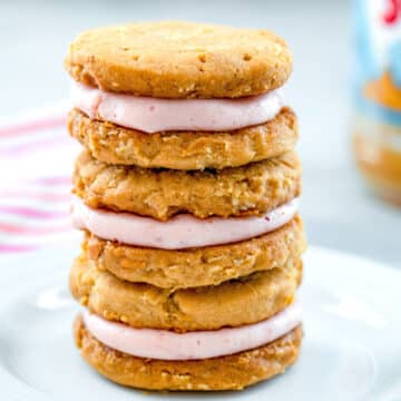 Closeup head-on view of a stack of peanut butter sandwich cookies with jelly frosting filling.