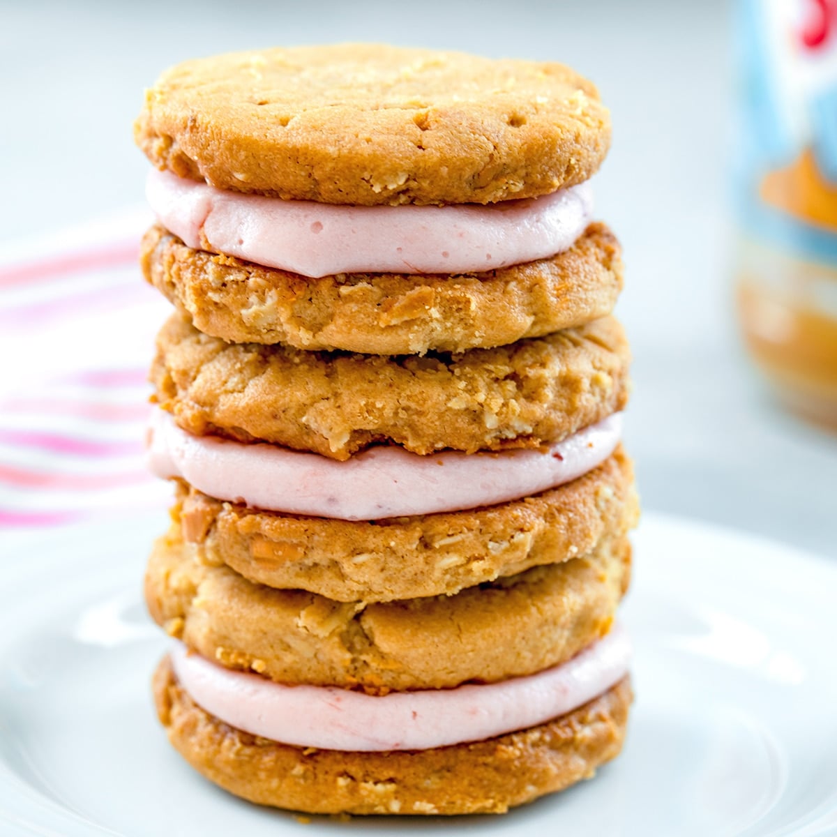 Closeup head-on view of a stack of peanut butter sandwich cookies with jelly frosting filling.