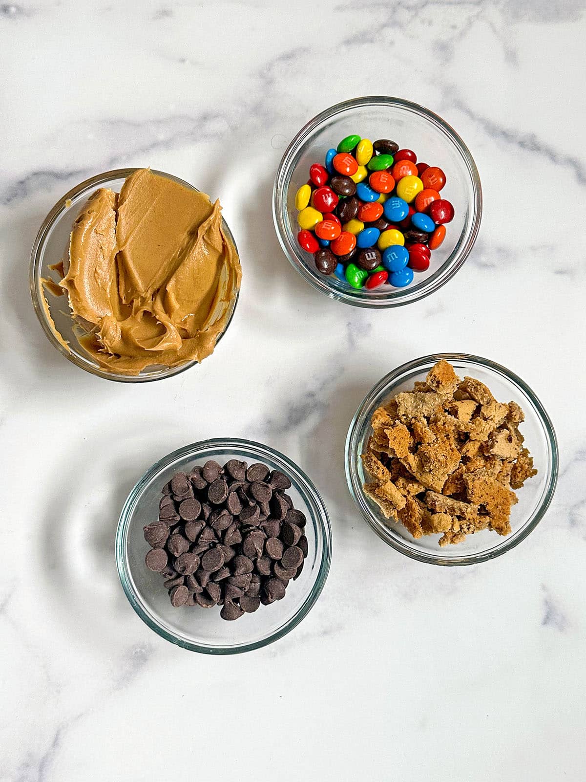 Add-ins for monster cookie ice cream, including peanut butter, M&Ms, chocolate chips, and oatmeal cookies.
