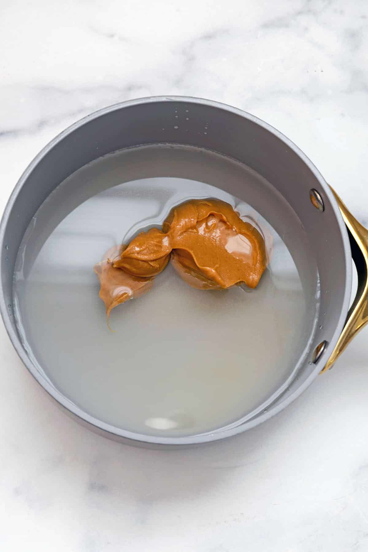 Peanut butter, sugar, and water in a saucepan.