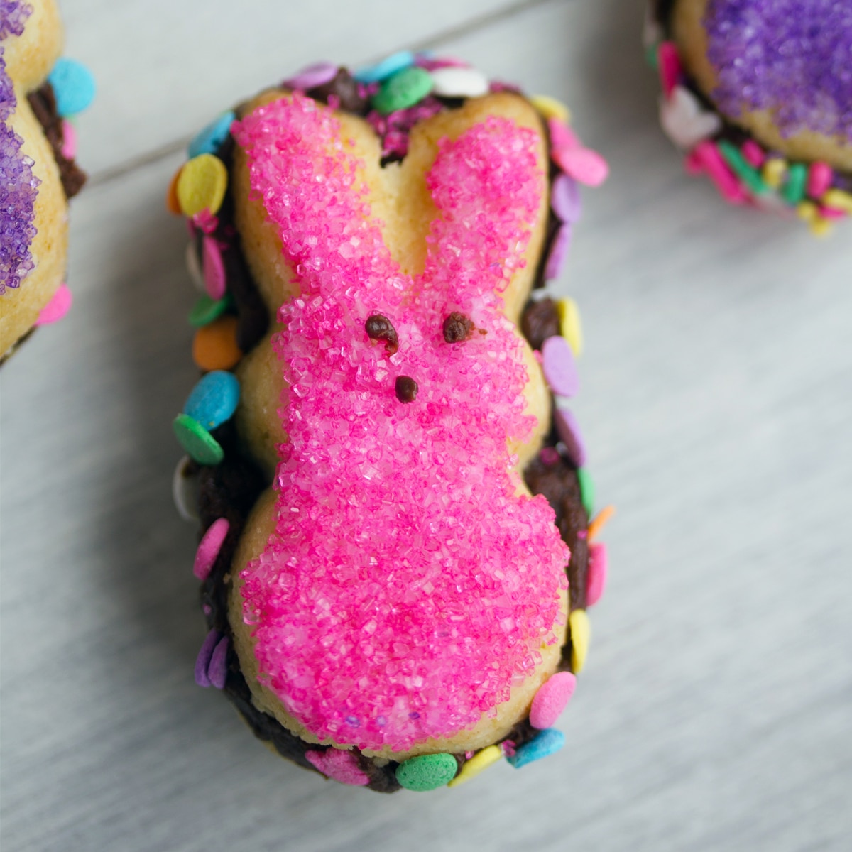 Closeup view of a bunny Peeps sandwich cookies with pink sprinkles.