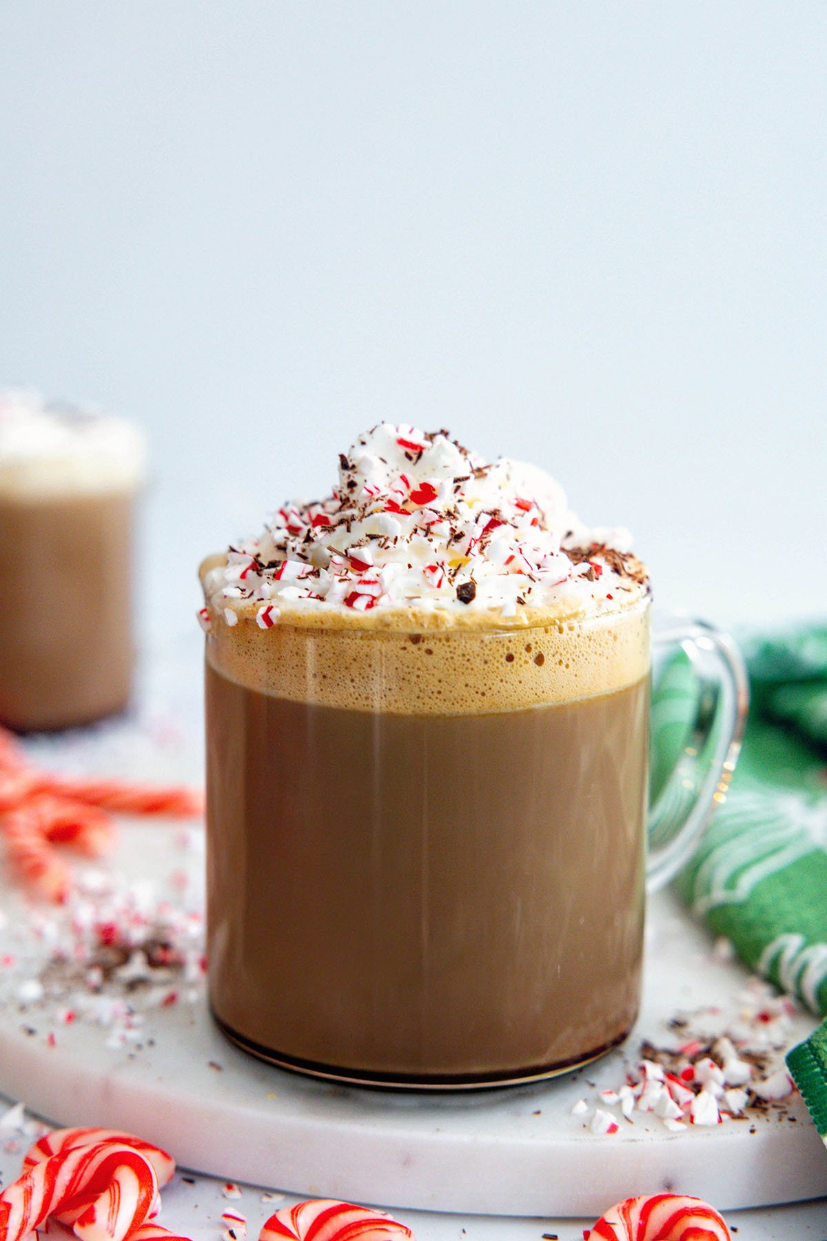 Head-on view of a Starbucks Peppermint Mocha with whipped cream, candy cane pieces.