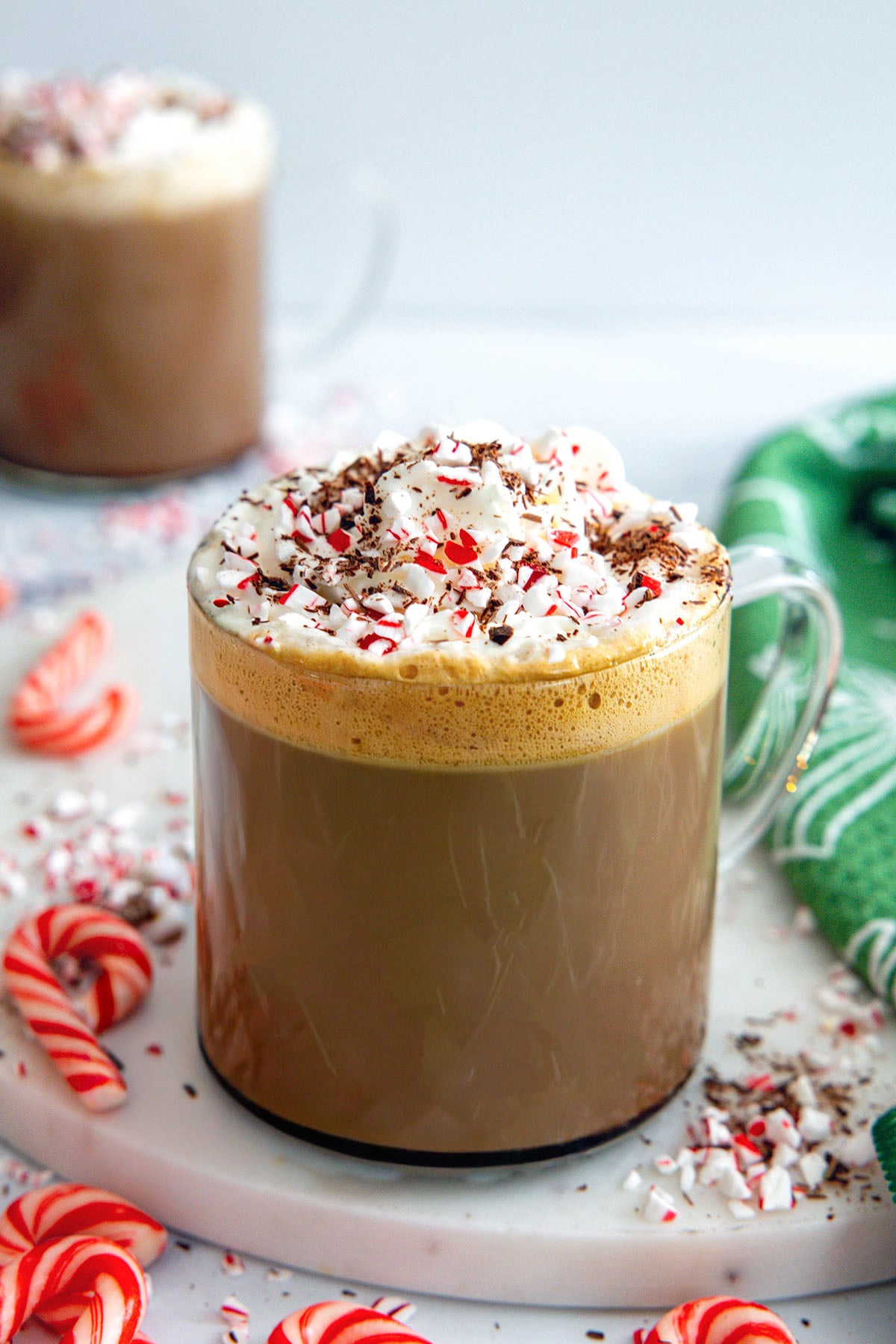 Overhead view of a Peppermint Mocha coffee drink with whipped cream, chocolate curls, and candy canes.