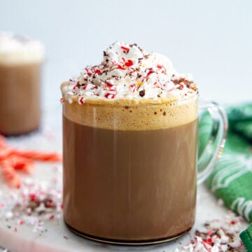 Closeup head-on view of a Peppermint Mocha topped with whipped cream, chocolate, and crushed peppermint.
