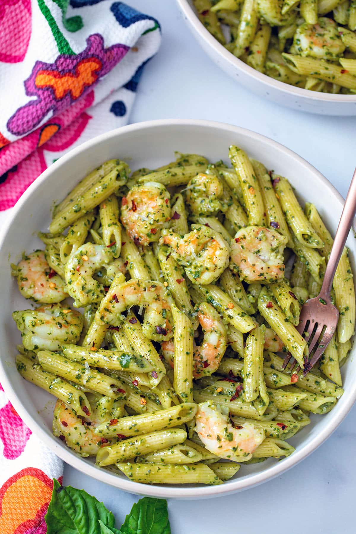 Pesto cream sauce pasta in bowl with shrimp.