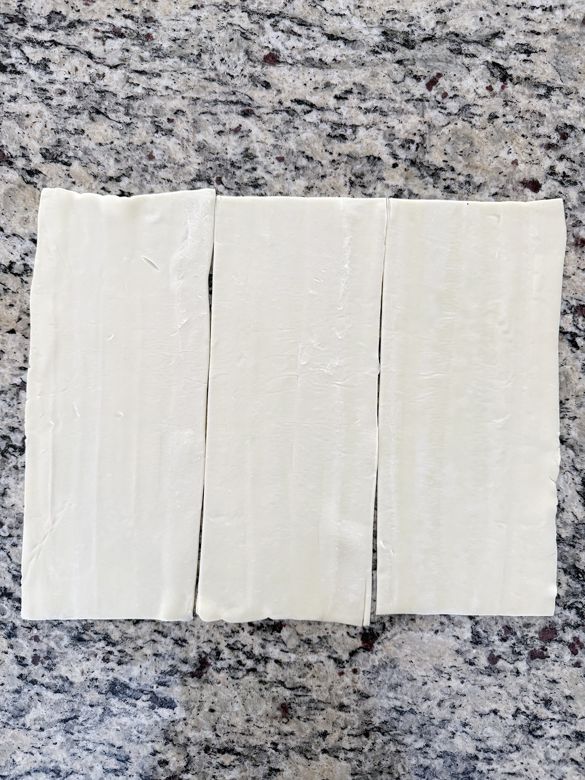 Sheet of phyllo dough cut into three rectangles.