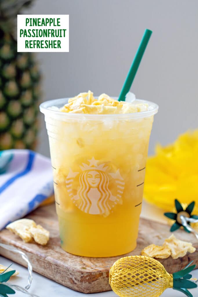 Head-on view of a pineapple passionfruit refresher with pineapple in background, pineapple lights all around, and recipe title at top.