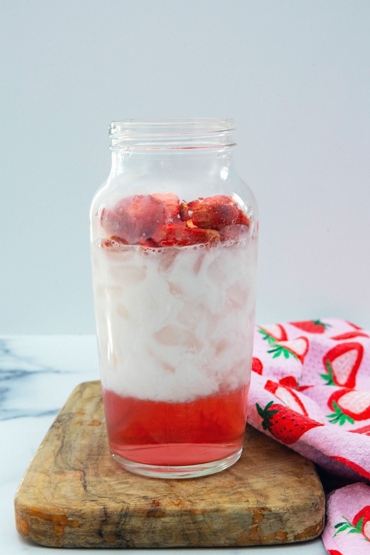 Shaker bottle filled with cran strawberry juice, coconut milk, and freeze-dried strawberries.