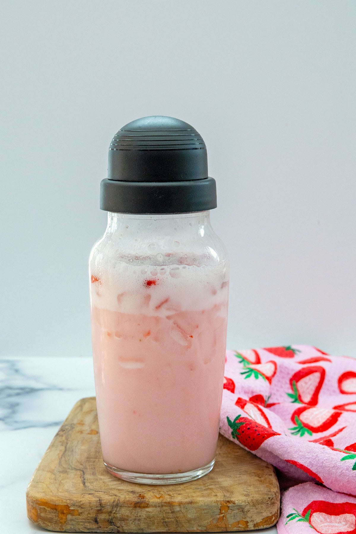 Pink Drink shook together in clear shaker with ice.