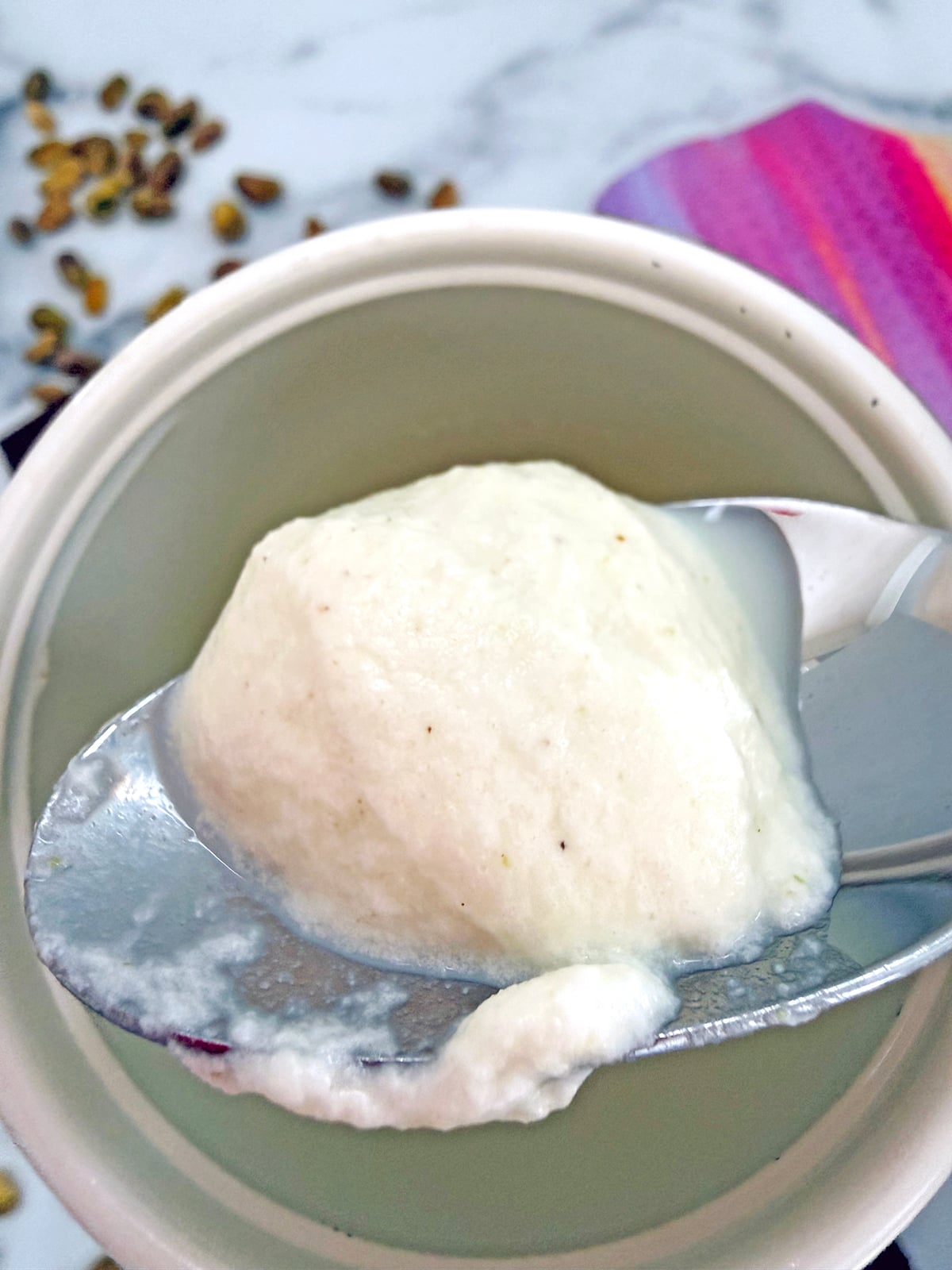 Pistachio cream cold foam on a spoon.