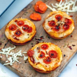 Closeup view of mini pepperoni pizza cupcakes on wooden board.